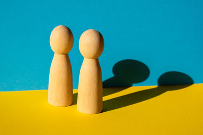 Close-up of wooden figurine against blue background