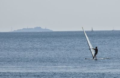 Man surfing on sea against sky