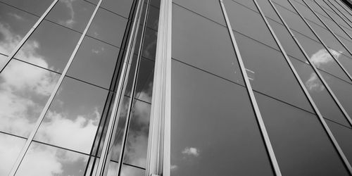 Low angle view of glass building against sky