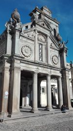 Low angle view of statues on building against sky