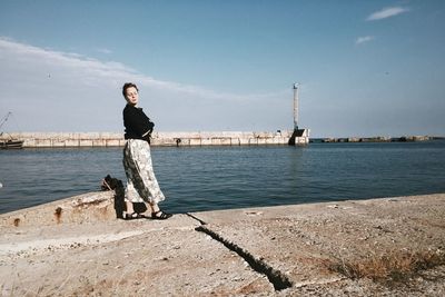 Full length of woman standing at promenade against sky