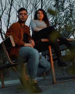 Young couple sitting on chair at park