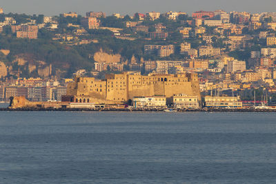 Buildings by sea against sky in city