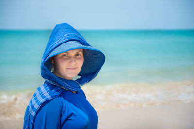 Portrait of mature man standing at beach against sky