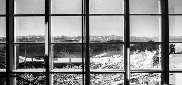 Scenic view of mountains seen through glass window