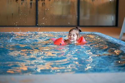 Cute girl swimming in pool
