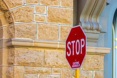 Close-up of sign against brick wall