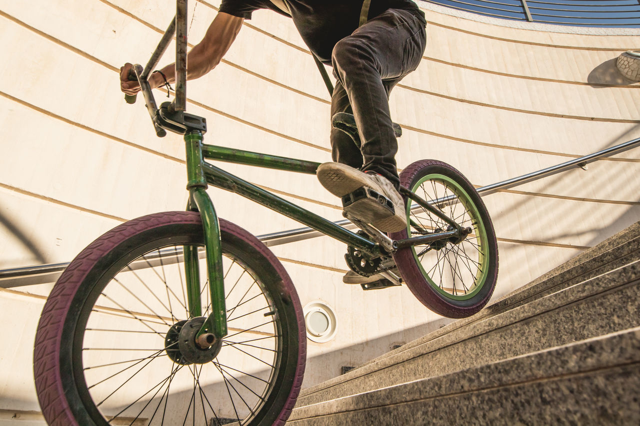 LOW SECTION OF MAN RIDING BICYCLE WITH WHEEL