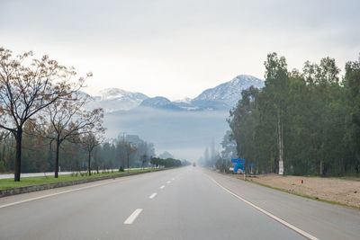 People walking on road against sky