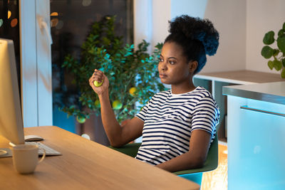 Black woman squeezing rubber expander. prevention of carpal tunnel syndrome after computer overwork