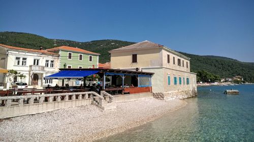 Built structure on beach against clear blue sky