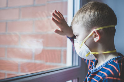 Portrait of boy looking through window