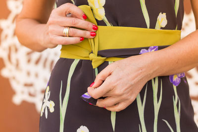 Midsection of woman tying knot