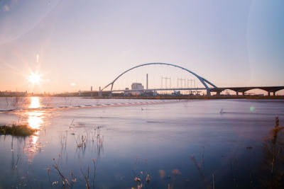 View of bridge over river at sunset