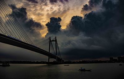 View of bridge over river against cloudy sky