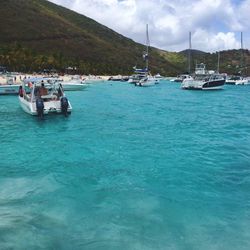 Boats in sea with mountain in background