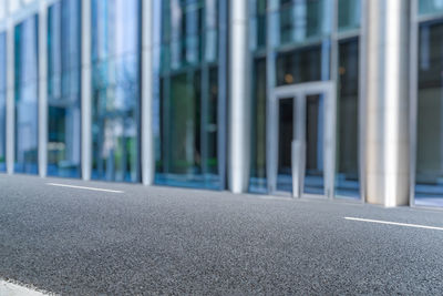 Empty road by buildings in city