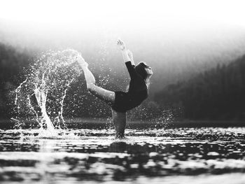 Side view of woman splashing water