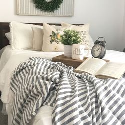 Potted plants with book and sheet on bed