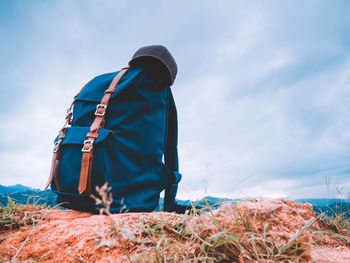 Backpack on land against sky