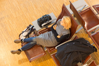 High angle view of woman sitting on wooden floor