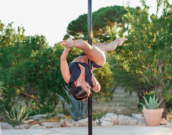 Man carrying swing while sitting on tree