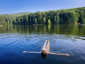 Young woman swimming in the lake on a sunny summer day