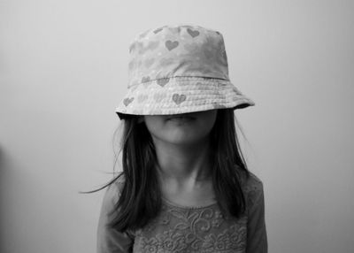 Girl wearing hat against wall at home