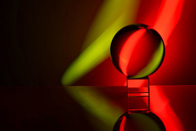 Close-up of multi colored glass ball on table against wall