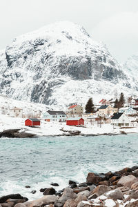 Building by snowcapped mountain against sky