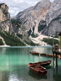 Boats moored on lake against mountain