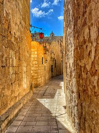Narrow alley amidst buildings against sky