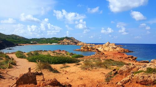 Scenic view of coast against cloudy sky