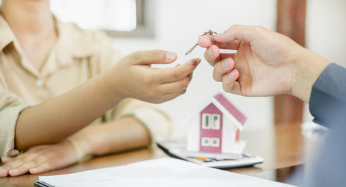 Midsection of doctor giving medicine to patient in office