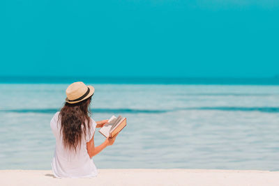 Rear view of woman wearing hat on beach