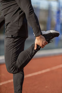 Low section of man exercising on field