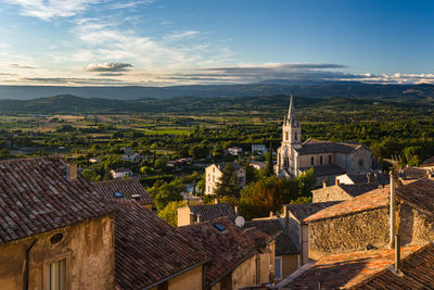 Town by landscape against sky