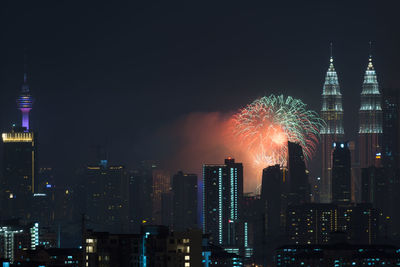 Firework display over city lit up at night