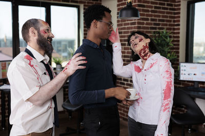 Portrait of business colleagues stacking hands in office