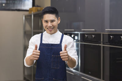 Portrait of chef gesturing in kitchen