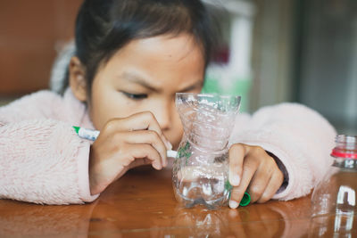 Portrait of boy drinking glass on table