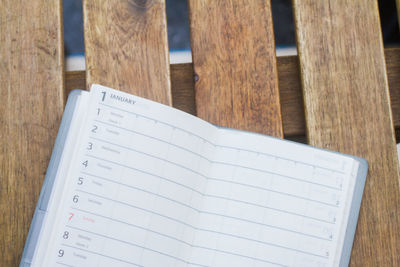 High angle view of open diary on wooden table