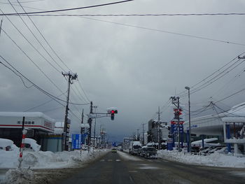 Cars on road against sky in winter