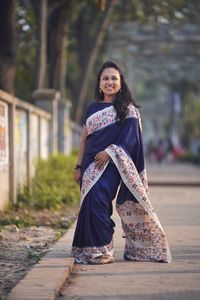 Portrait of a smiling young woman wearing saree  standing outdoors