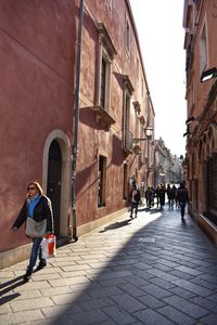 People walking on street amidst buildings