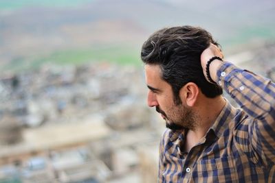 Close-up of thoughtful man looking away with hand in hair