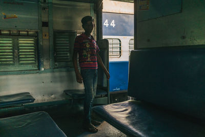 Rear view of man looking at abandoned building