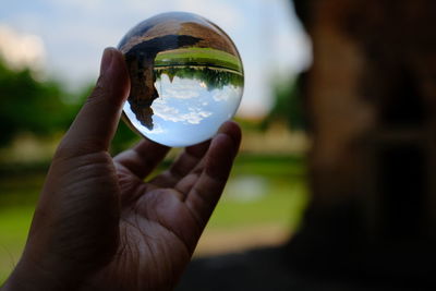 Close-up of hand holding crystal ball