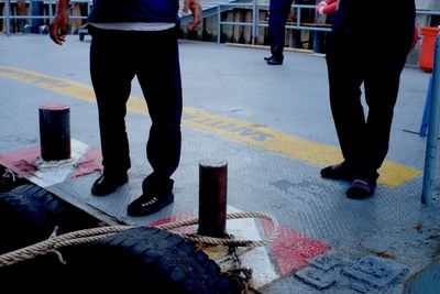 Low section of men by rope at bollard