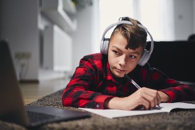 Bow wearing headphones studying at home